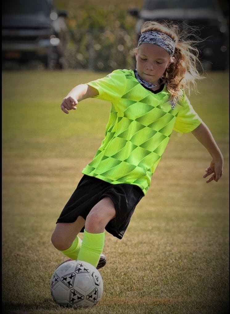 Girl preparing to kick a soccer ball